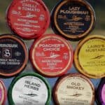 Fine Cheesemakers of Scotland: Isle of Kintyre range of flavoured wax-truckle cheddars stacked up.