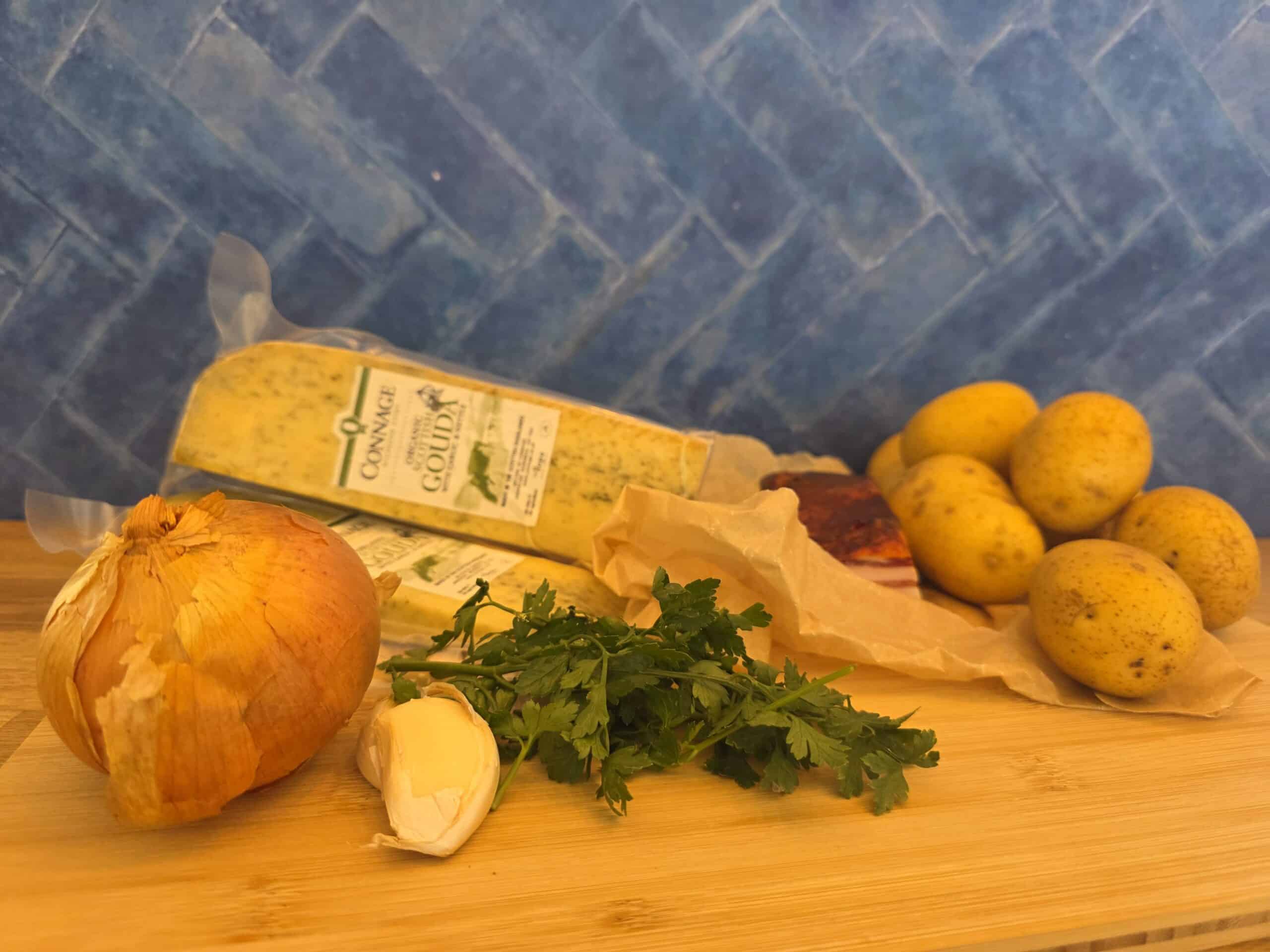Fine Cheesemakers of Scotland -Connage Tartiflette Ingredients on a wooden board. Fine Cheesemakers of Scotland -Connage Tartiflette Ingredients on a wooden board.